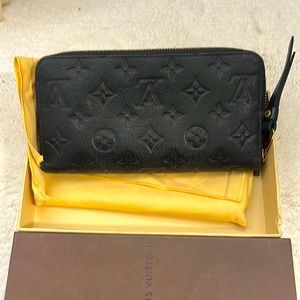 LV navy leather embossed 8 in x 4 in wallet with zip closure.